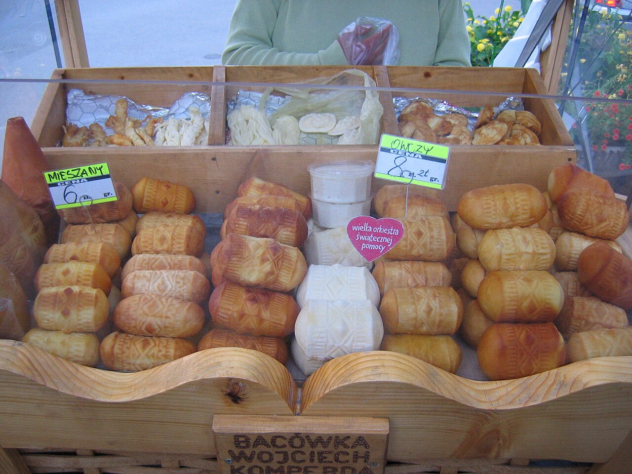 Spindle-shaped smoked oscypek cheeses on a market stall