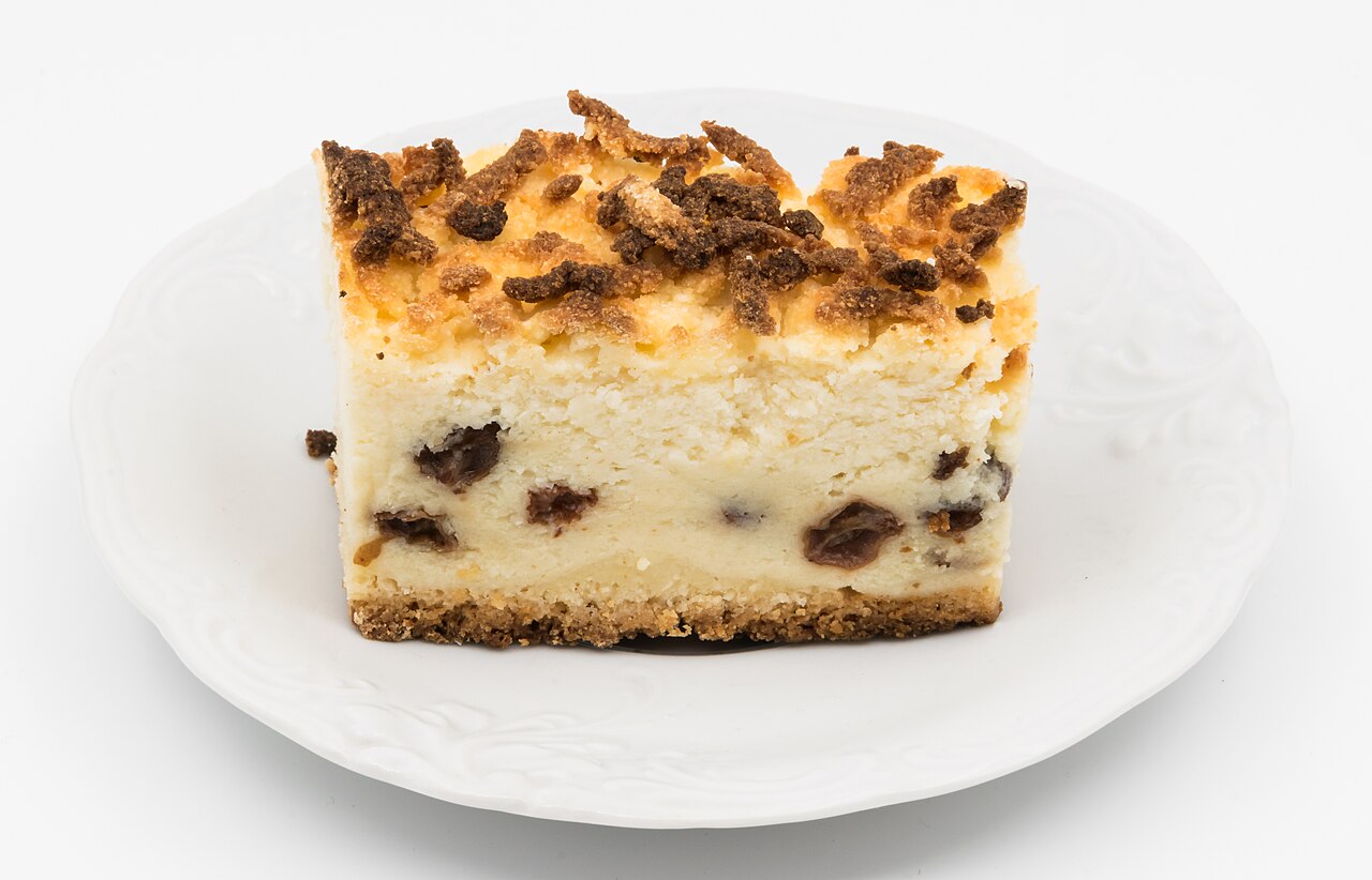 A slice of Polish sernik cheesecake with raisins
