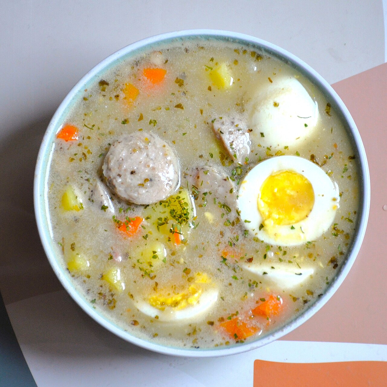 A bowl of żurek, sour rye soup with a boiled egg